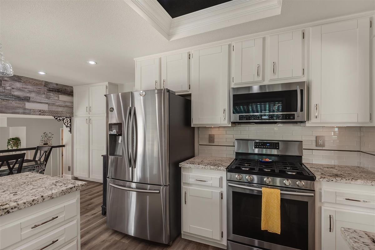 1428 Eagles Nest Lane Gilroy, CA 95020 - Photo 14 of 38 a kitchen with stainless steel appliances granite countertop a stove a refrigerator and a white cabinets
