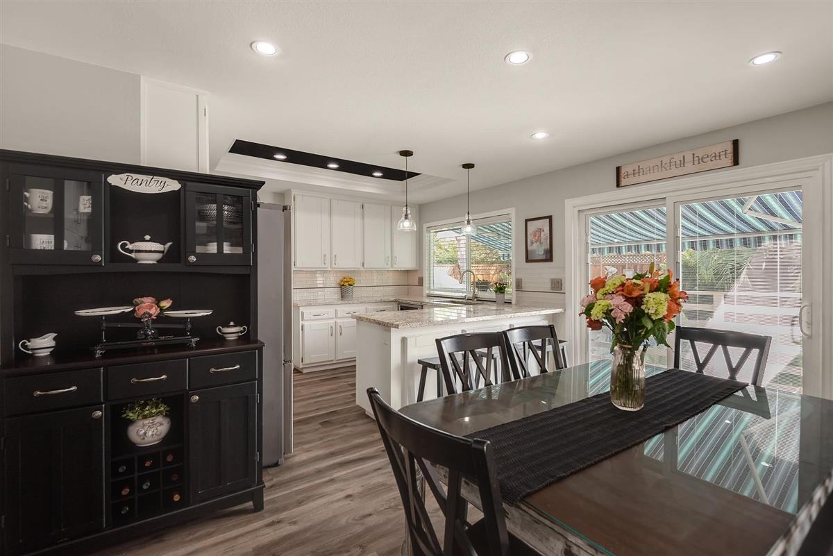 1428 Eagles Nest Lane Gilroy, CA 95020 - Photo 16 of 38 a kitchen with stainless steel appliances granite countertop a refrigerator a stove top oven and a dining table with wooden floor
