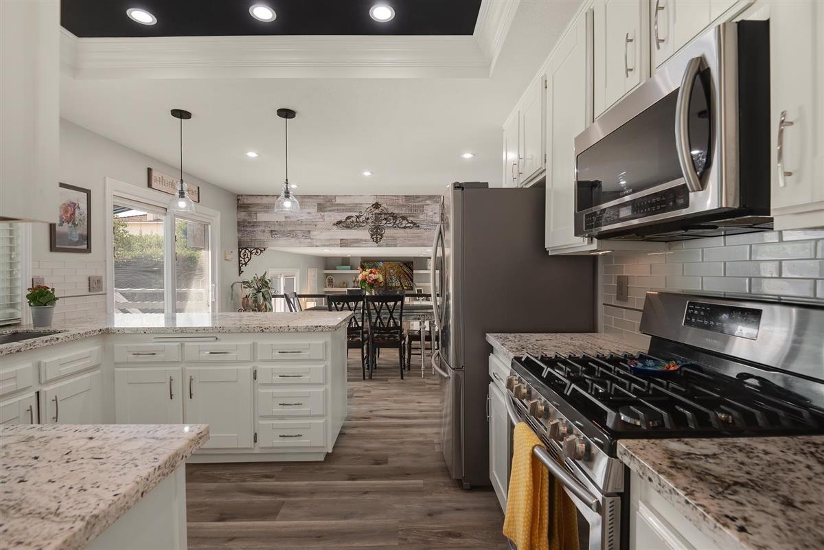 1428 Eagles Nest Lane Gilroy, CA 95020 - Photo 10 of 38 a kitchen with stainless steel appliances granite countertop a stove top oven a sink dishwasher and a microwave oven with wooden floor