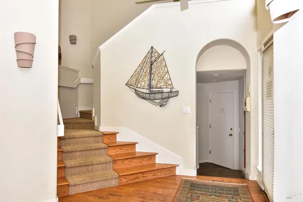 a view of entryway and hall with wooden floor