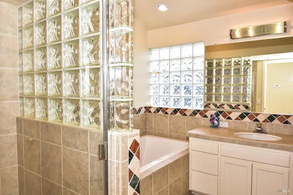 a bathroom with a tub sink and mirror