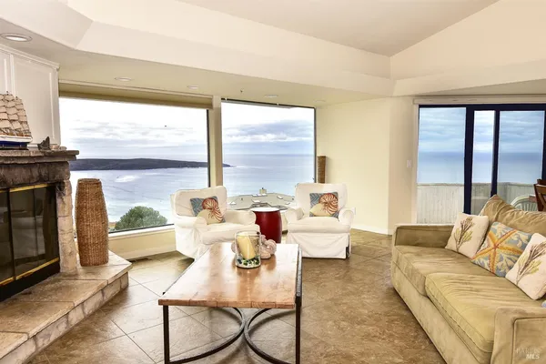 a living room with furniture a large window and a fireplace