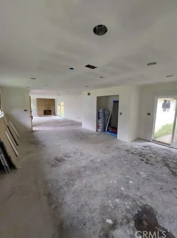 a view of an empty room with a fireplace and a window