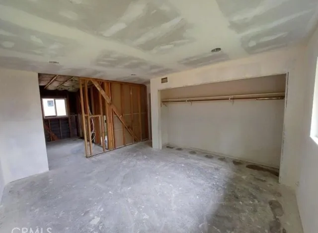 an empty room with closet and mirror