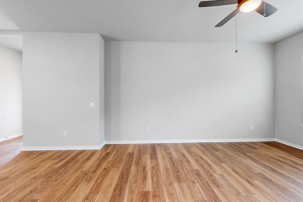 4907 Escape Rivera Drive Austin, TX 78747 - Photo 24 of 28 Rich hardwood-style flooring extends across this spacious, light-filled living area.