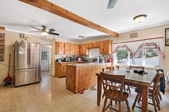 a kitchen with refrigerator a stove and a dining table