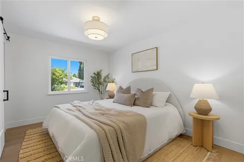 a bedroom with a bed and a painting on the wall