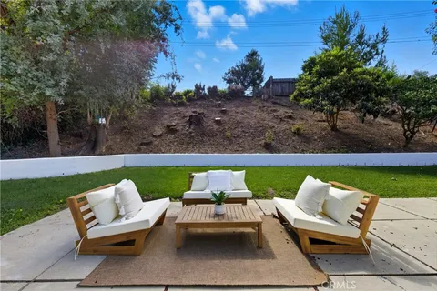 an outdoor sitting area with chairs and a table