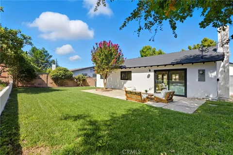 a front view of a house with garden and sitting area