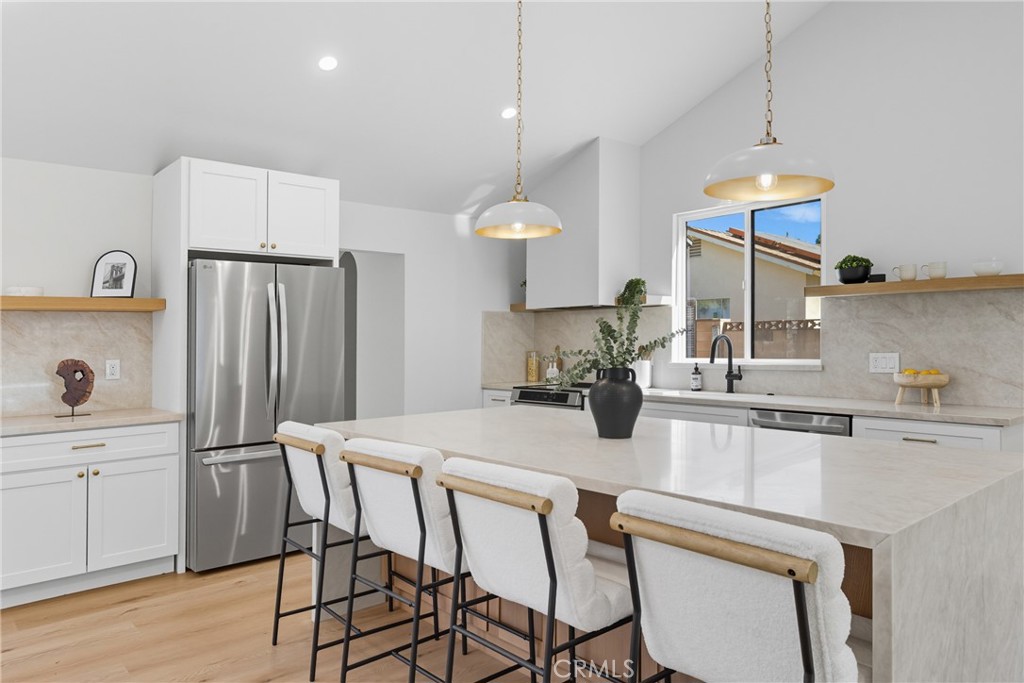 226 Tennyson Street Thousand Oaks, CA 91360 - Photo 4 of 27 a kitchen with stainless steel appliances granite countertop a sink a stove a refrigerator and island with wooden floor