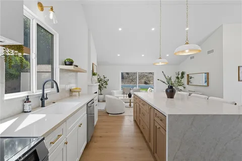 a large kitchen with a sink and large windows