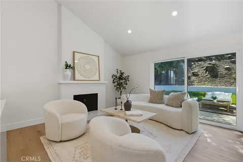 a living room with furniture a fireplace and a large window