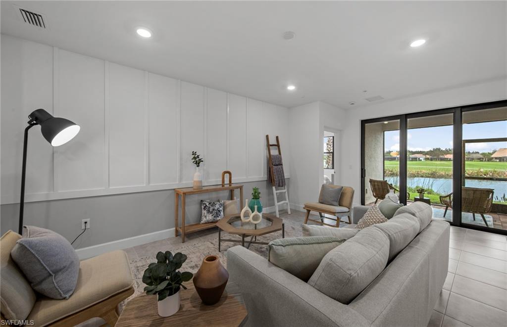 5693 Mayflower Way, Unit 1107 Ave Maria, FL 34142 - Photo 11 of 46 a living room with furniture and a floor to ceiling window