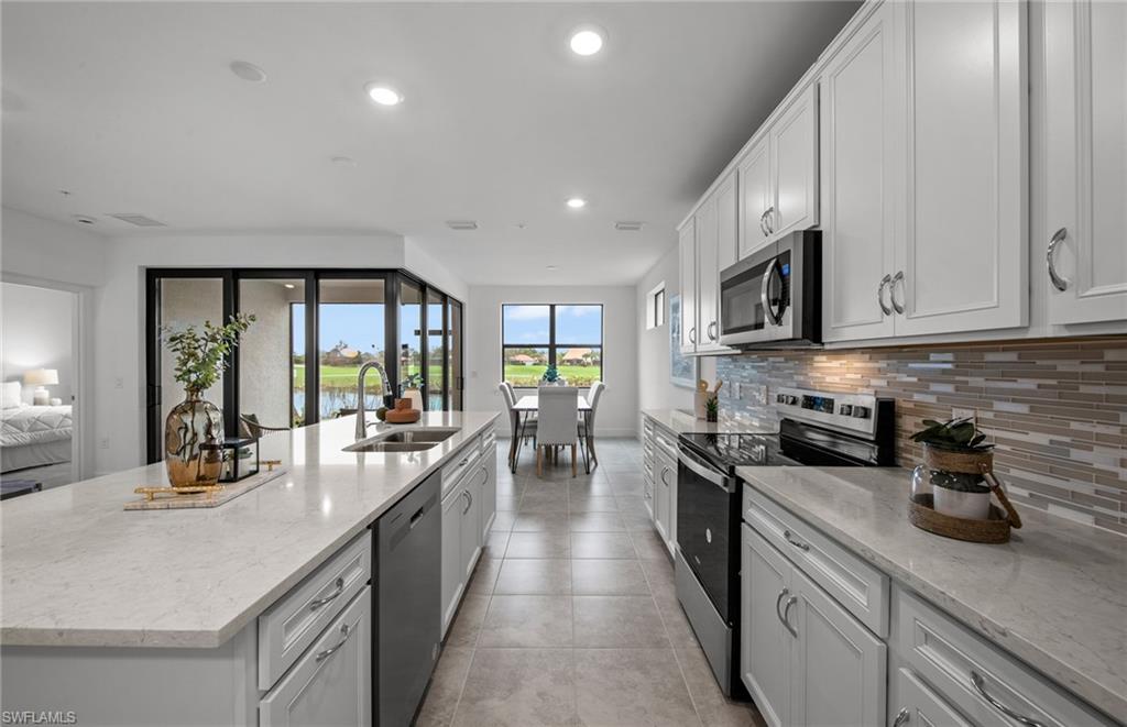 5693 Mayflower Way, Unit 1107 Ave Maria, FL 34142 - Photo 17 of 46 a large kitchen with stainless steel appliances granite countertop a lot of counter space and wooden floors