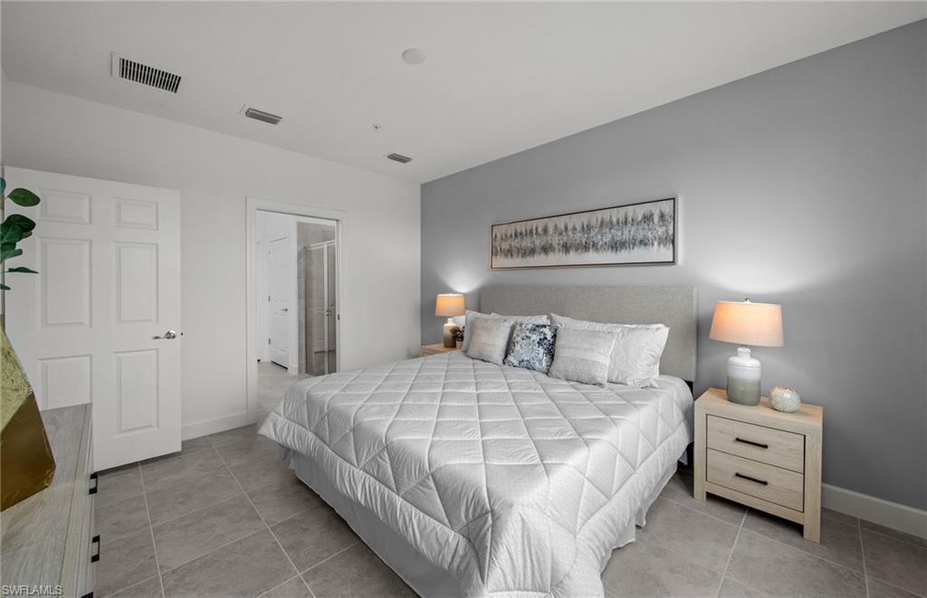 5693 Mayflower Way, Unit 1107 Ave Maria, FL 34142 - Photo 27 of 46 a bedroom with a bed and a night stand