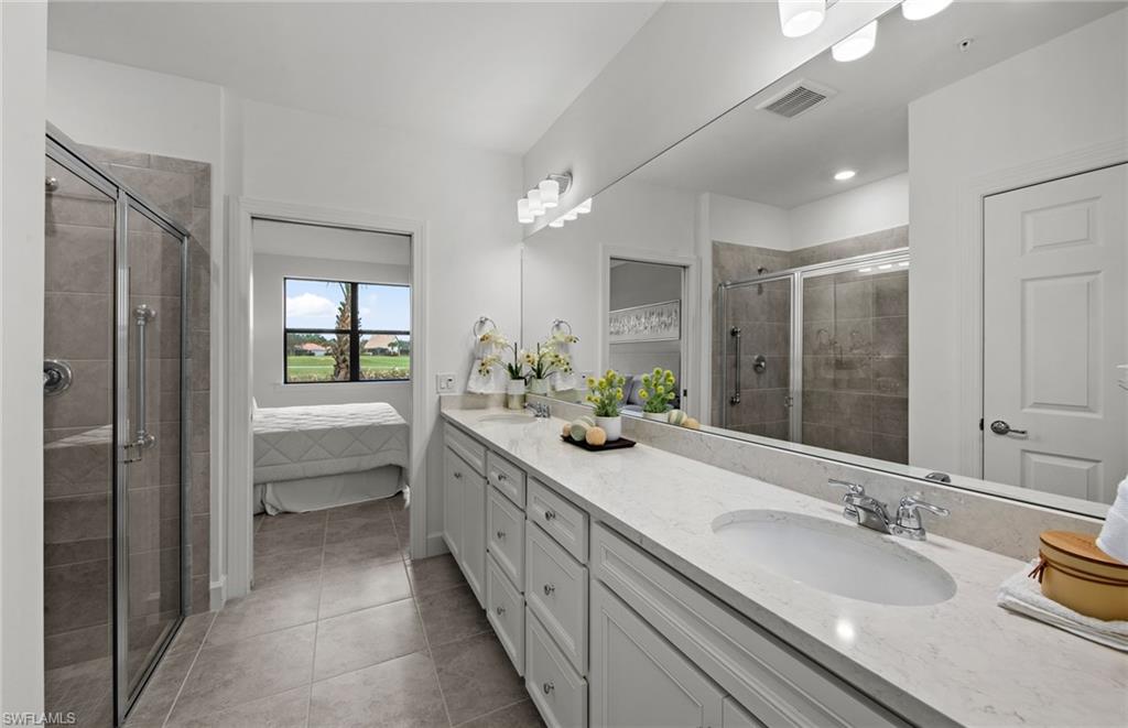 5693 Mayflower Way, Unit 1107 Ave Maria, FL 34142 - Photo 29 of 46 a bathroom with a granite countertop sink mirror and a bathtub