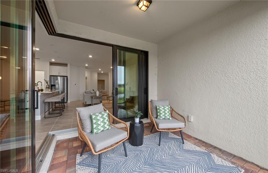 5693 Mayflower Way, Unit 1107 Ave Maria, FL 34142 - Photo 33 of 46 a living room with furniture and a table