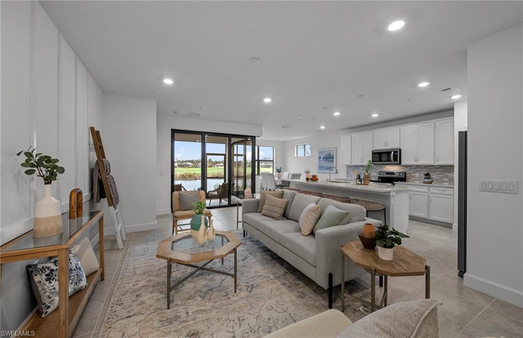 5693 Mayflower Way, Unit 1107 Ave Maria, FL 34142 - Photo 8 of 46 a living room with furniture and a view of kitchen