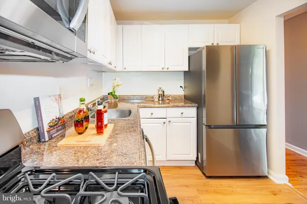 a kitchen with stainless steel appliances granite countertop a refrigerator and a stove
