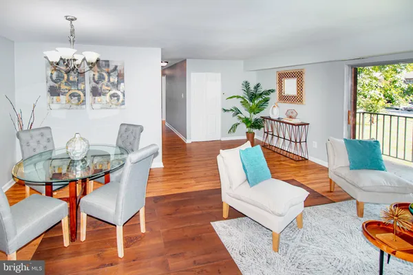 a living room with furniture a chandelier and a dining table