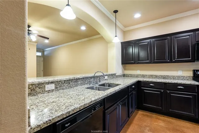a kitchen with a sink and a stove top oven with wooden floor
