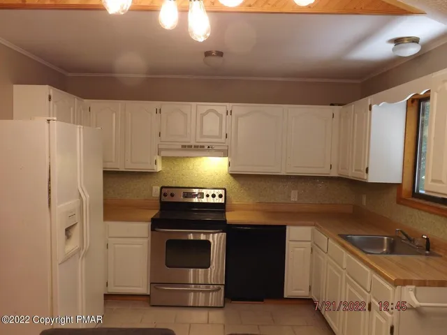 a kitchen with stainless steel appliances granite countertop a stove a refrigerator and a sink