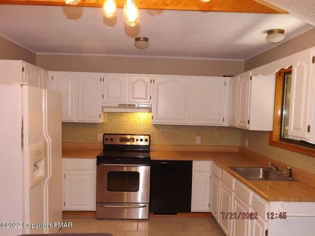 a kitchen with a stove a refrigerator and a sink