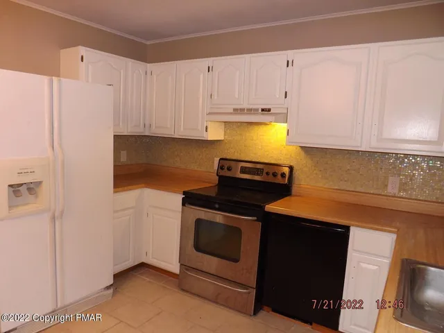 a kitchen with granite countertop white cabinets and stainless steel appliances