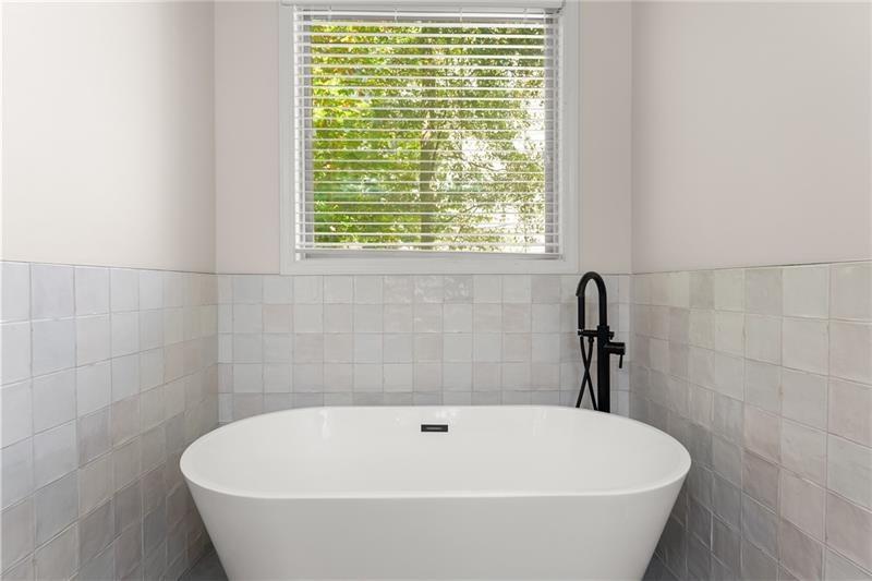8055 Veranda Curve Ball Ground, GA 30107 - Photo 35 of 65 a white bath tub sitting in a bathroom next to a window