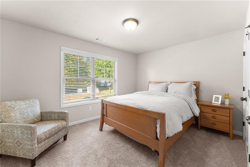 8055 Veranda Curve Ball Ground, GA 30107 - Photo 37 of 65 a spacious bedroom with a bed and a couch