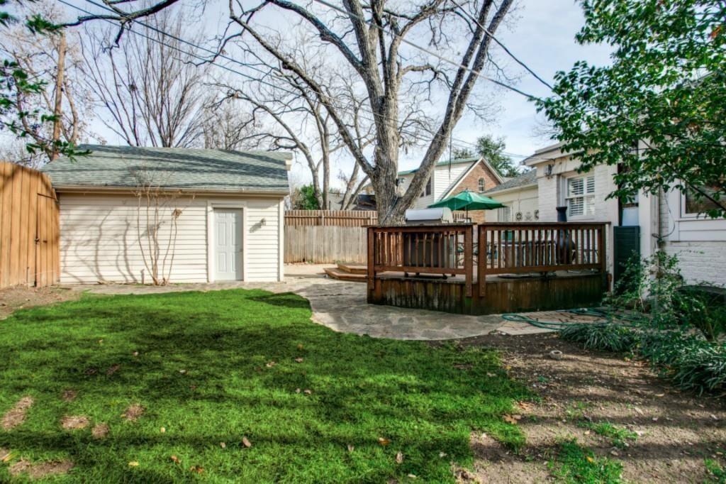 5419 Merrimac Avenue Dallas, TX 75206 - Photo 3 of 17 Expansive backyard featuring a manicured lawn, a detached storage building with horizontal siding, and a raised wood-finish deck with railings