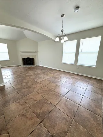 a view of an empty room with a fireplace and a window