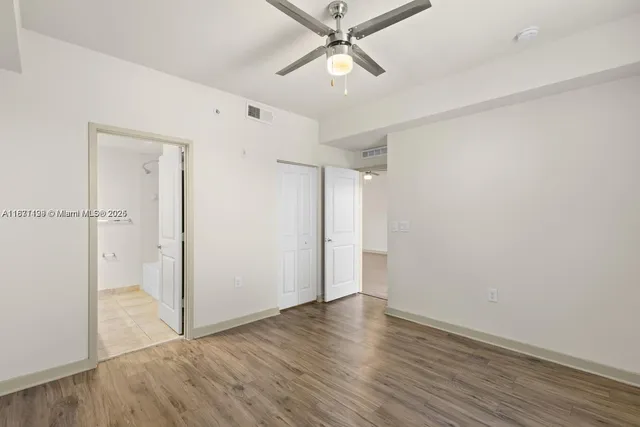 a view of an empty room with wooden floor