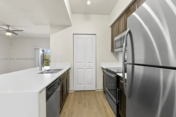 a kitchen with granite countertop a refrigerator and a sink