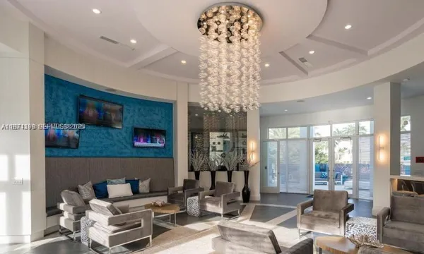 a living room with furniture and a chandelier