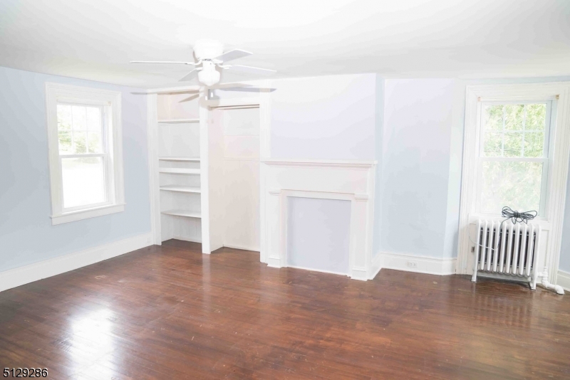 168 East Main Street Lebanon, NJ 08833 - Photo 15 of 33 an empty room with wooden floor chandelier fan and windows