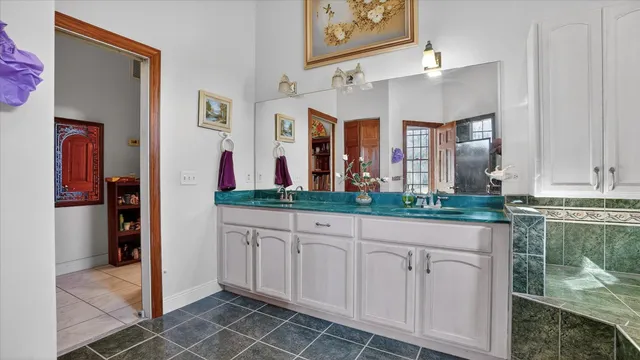 a en suite bathroom with a sink mirror and a shower