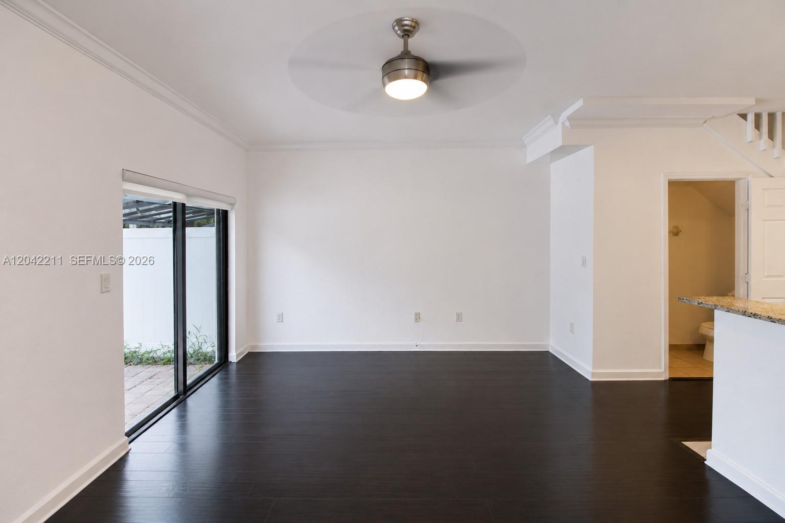 8954 West 35th Way Hialeah, FL 33018 - Photo 10 of 24 an empty room with wooden floor and windows