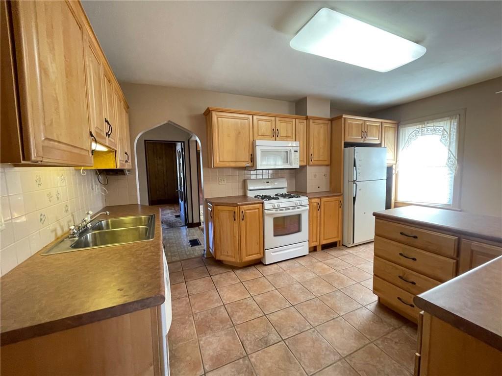 405 Routh Street Monroeville, PA 15146 - Photo 12 of 18 a kitchen with stainless steel appliances a stove a sink a microwave and a refrigerator
