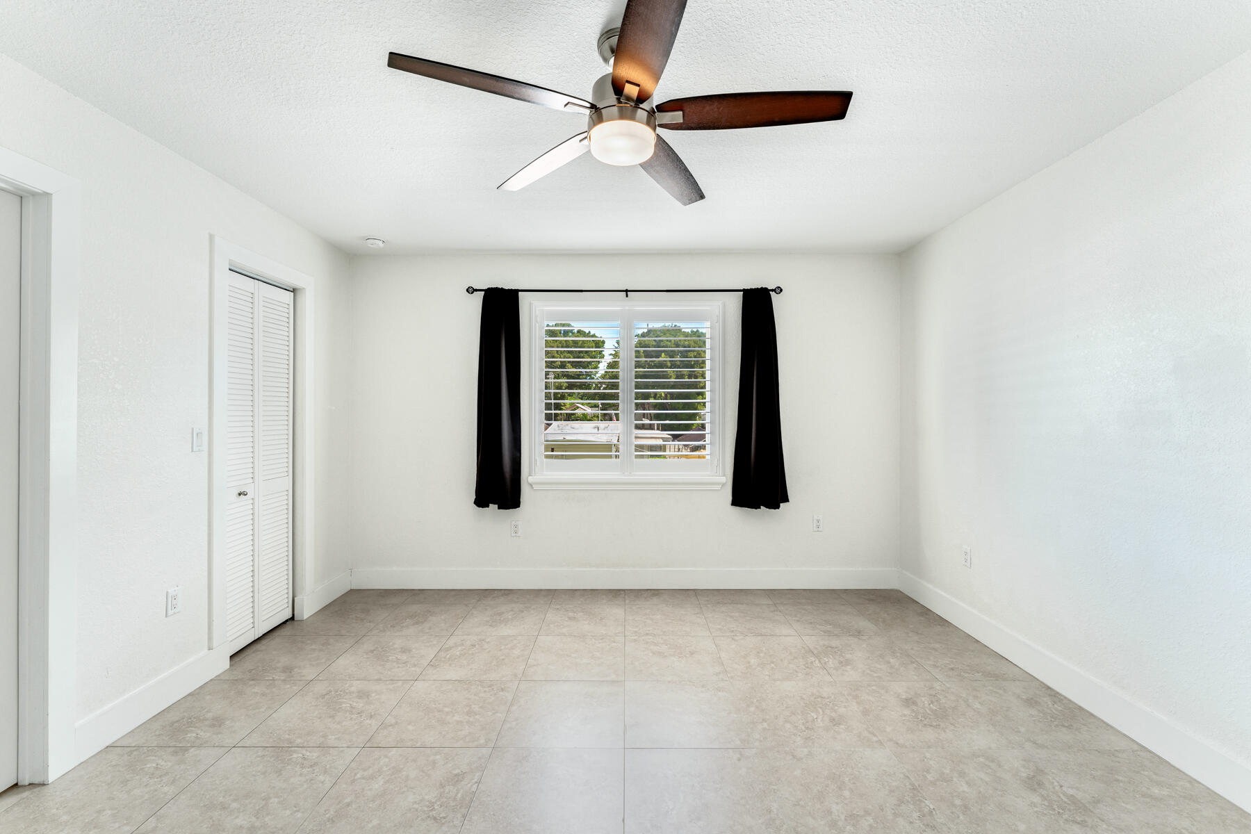 955 Plantation Road Key Largo, FL 33037 - Photo 21 of 37 an empty room with windows and fan