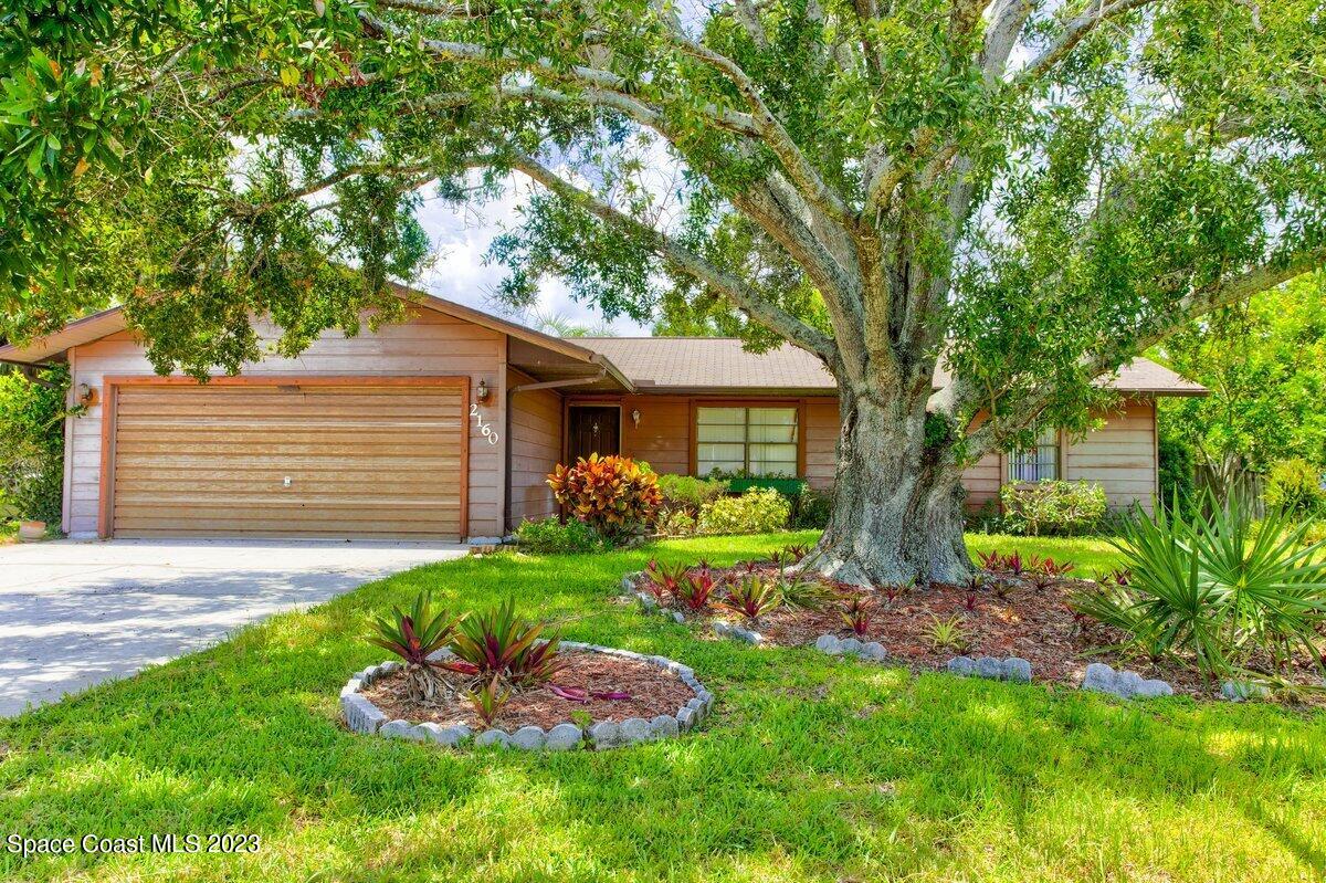 2160 Stewart Road Melbourne, FL 32935 - Photo 1 of 18 a front view of a house with a yard and garage