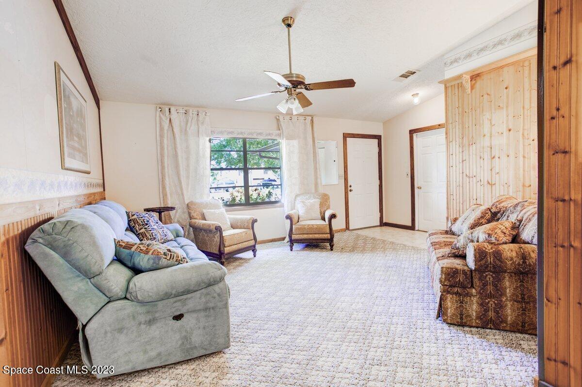 2160 Stewart Road Melbourne, FL 32935 - Photo 2 of 18 a living room with furniture and a chandelier