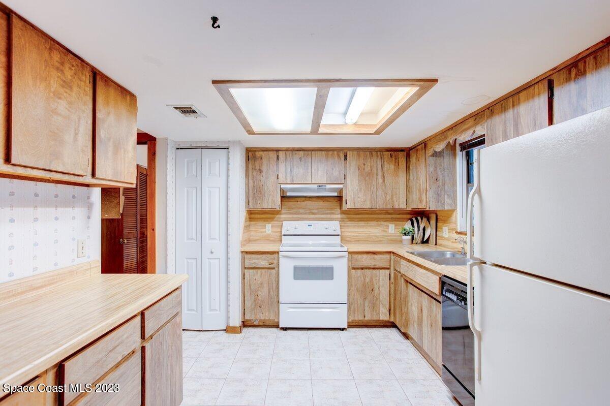 2160 Stewart Road Melbourne, FL 32935 - Photo 4 of 18 a kitchen with a refrigerator and a sink