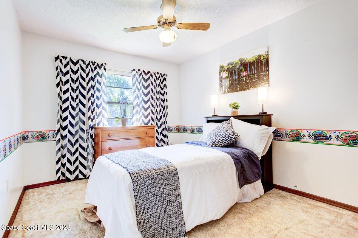 2160 Stewart Road Melbourne, FL 32935 - Photo 7 of 18 a bedroom with bed and a chandelier