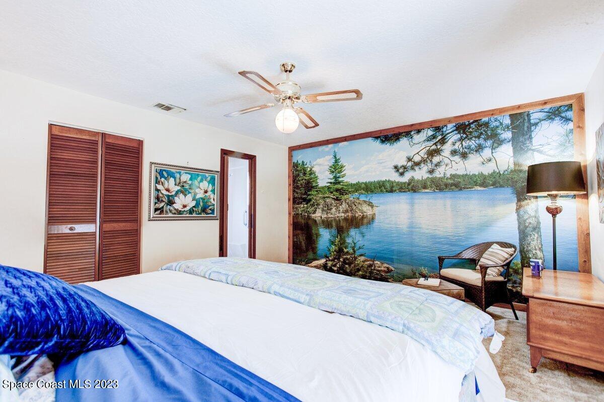 2160 Stewart Road Melbourne, FL 32935 - Photo 9 of 18 a bedroom with a bed and a chandelier