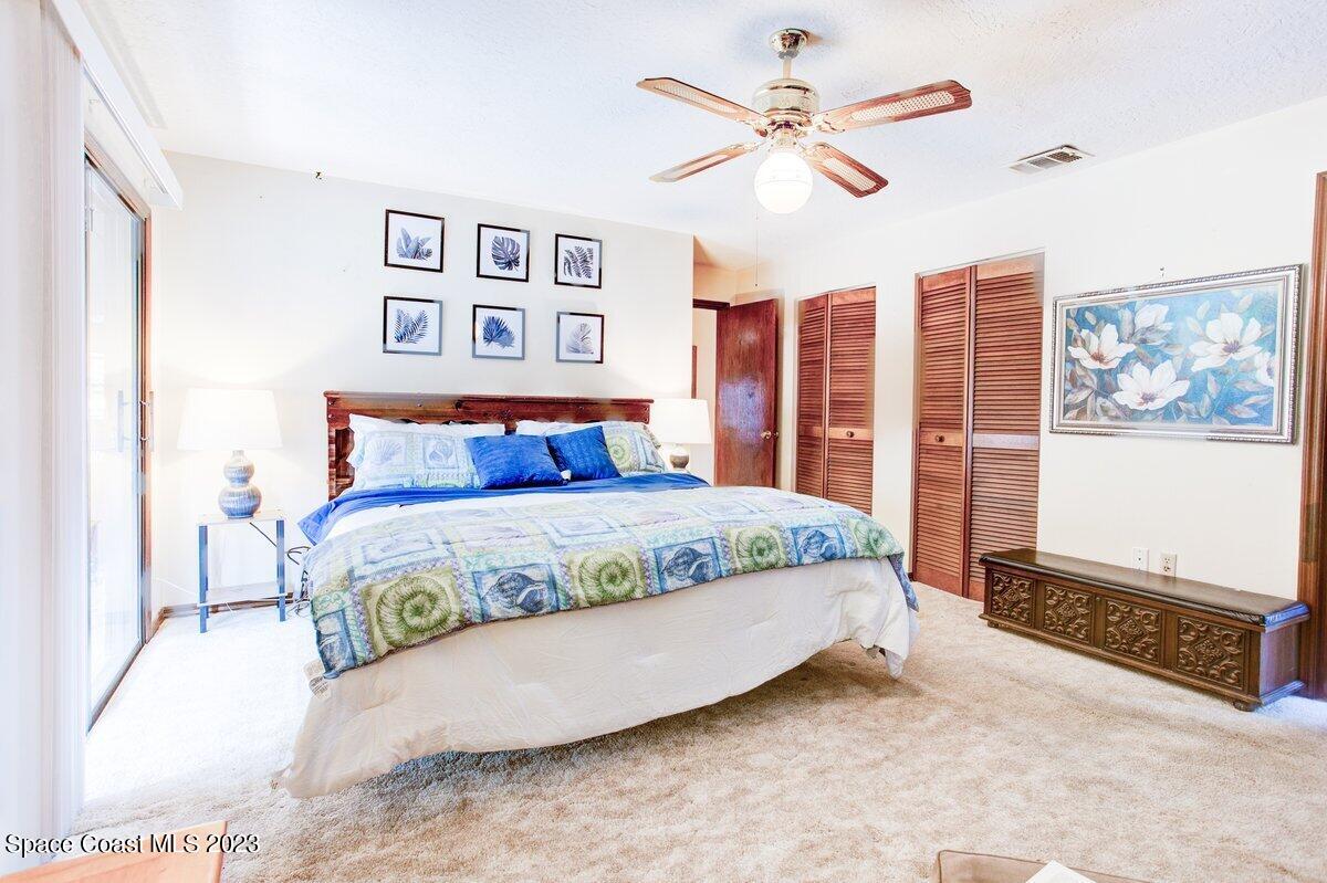 2160 Stewart Road Melbourne, FL 32935 - Photo 10 of 18 a bedroom with a large bed and a chandelier
