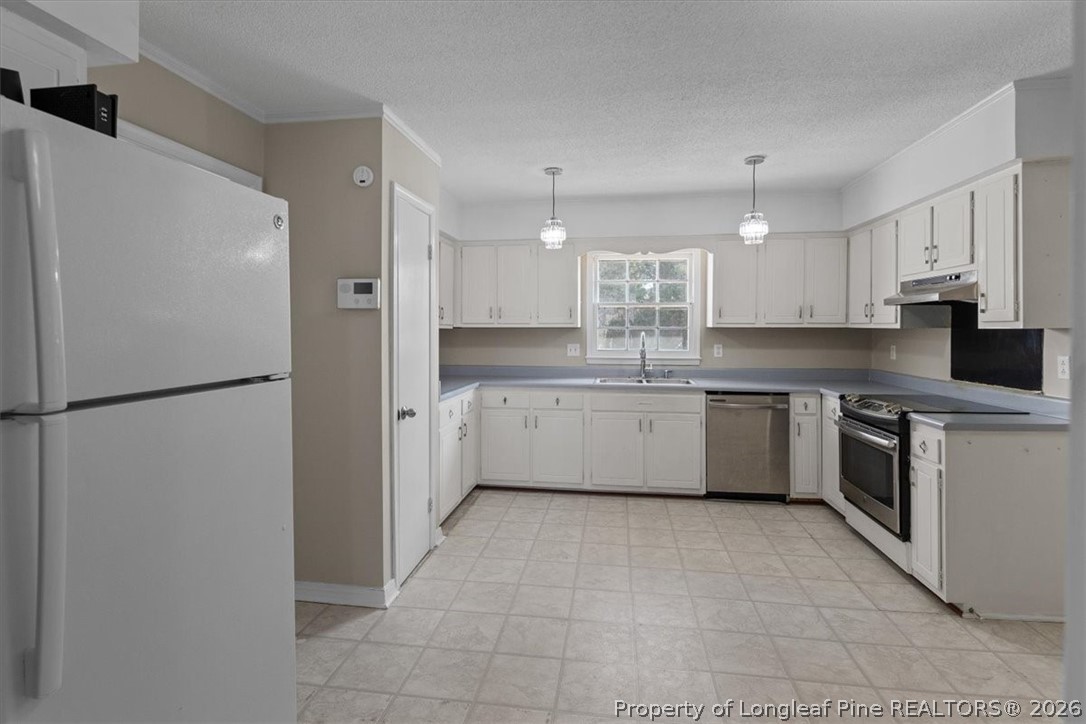630 Bedford Road Fayetteville, NC 28303 - Photo 7 of 21 a kitchen with a sink refrigerator and cabinets