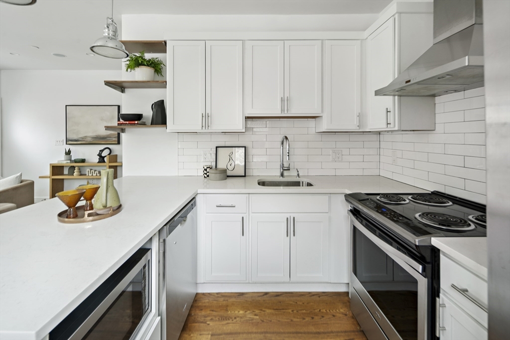 9 Cedar Street, Unit 1 Boston, MA 02119 - Photo 7 of 25 a kitchen with stainless steel appliances granite countertop a sink stove and cabinets