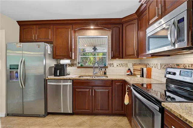 a kitchen with stainless steel appliances granite countertop a stove a sink dishwasher and a refrigerator