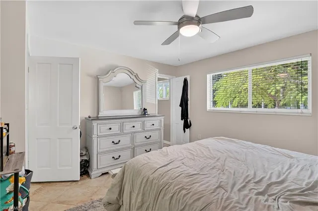 a bedroom with a bed and a dresser with mirror